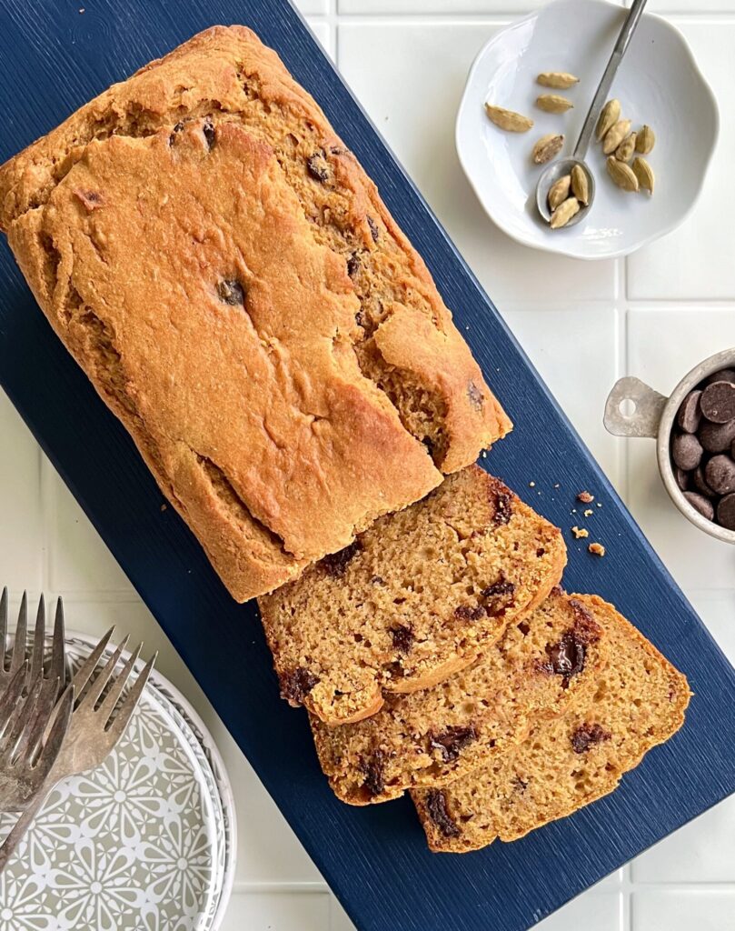 Overhead view of sweet potato bread with a few slices cut on top of a blue cutting board.