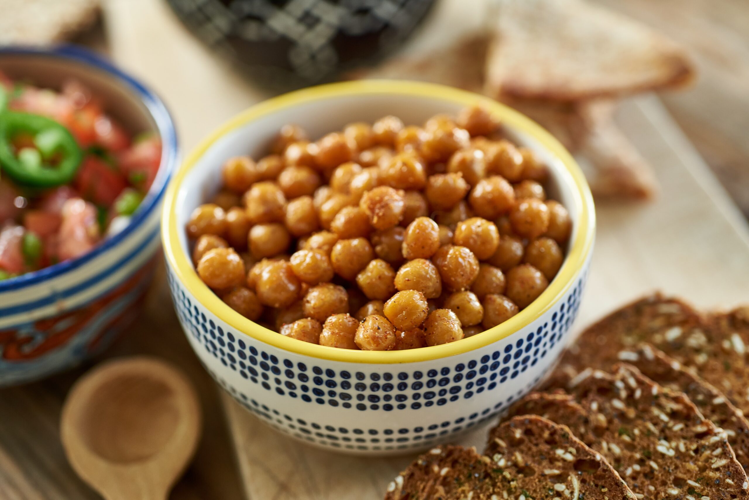 3/4 overhead shot of a bowl of crispy chickpeas. The bowl is blue and white with a yellow rim. It's a close up shot.