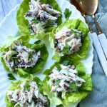 5 scoops of chicken salad on pieces of bibb lettuce. Overhead shot.