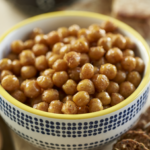 3/4 overhead shot of a bowl of crispy chickpeas. The bowl is blue and white with a yellow rim. It's a close up shot.