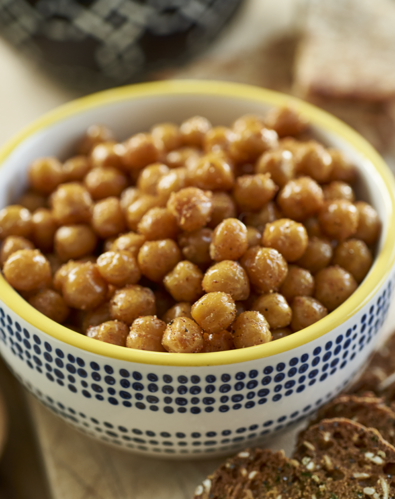 3/4 overhead shot of a bowl of crispy chickpeas. The bowl is blue and white with a yellow rim. It's a close up shot.