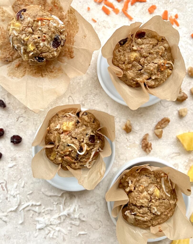 Overhead view of 4 muffins wrapped in paper.