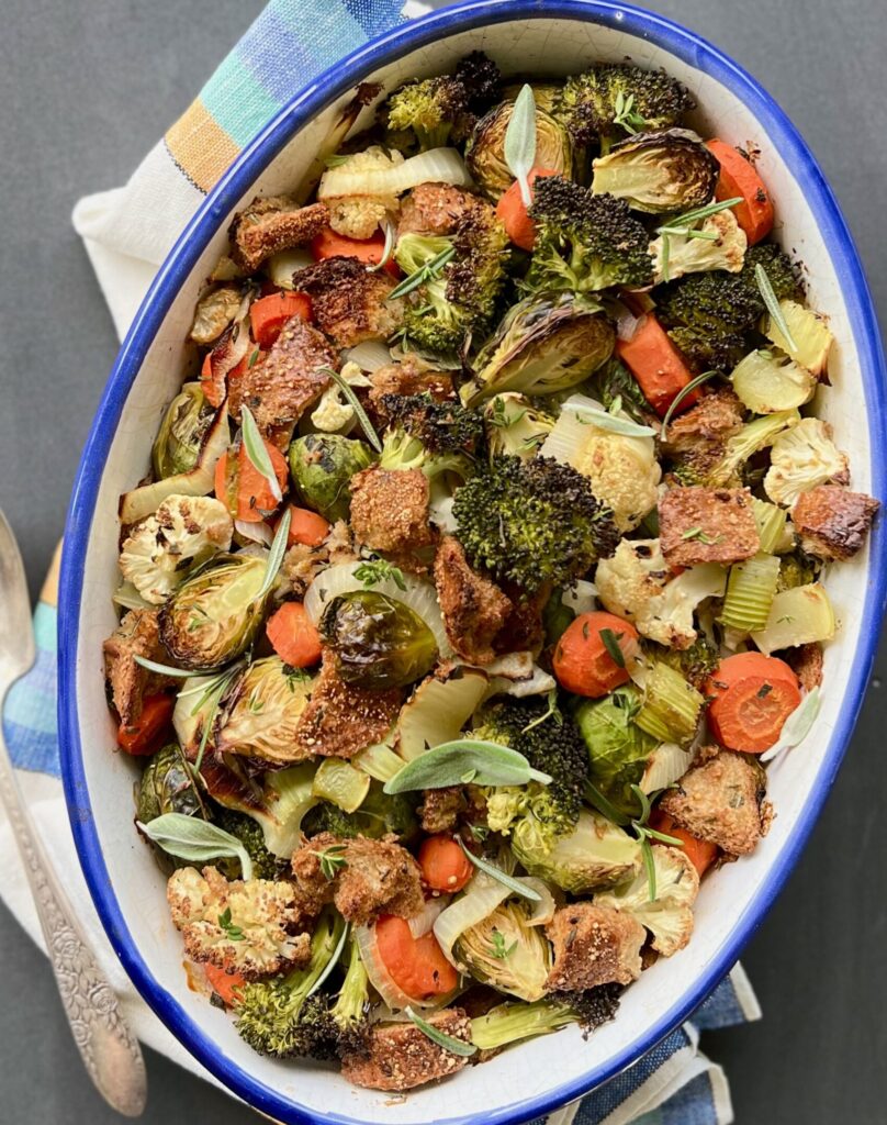 Overhead view of a large white bowl with a blue rim filled with the roasted vegetable stuffing.